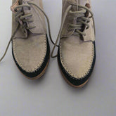 Pair of brown suede shoes on a light gray tiled floor